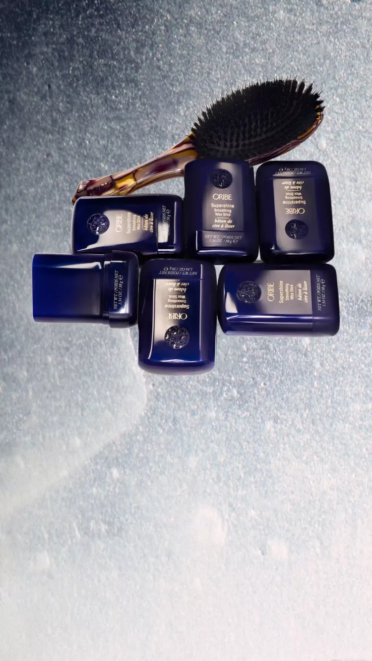 John Lewis new beauty arrivals featuring Oribe hair styling products and boar bristle brush on silver background