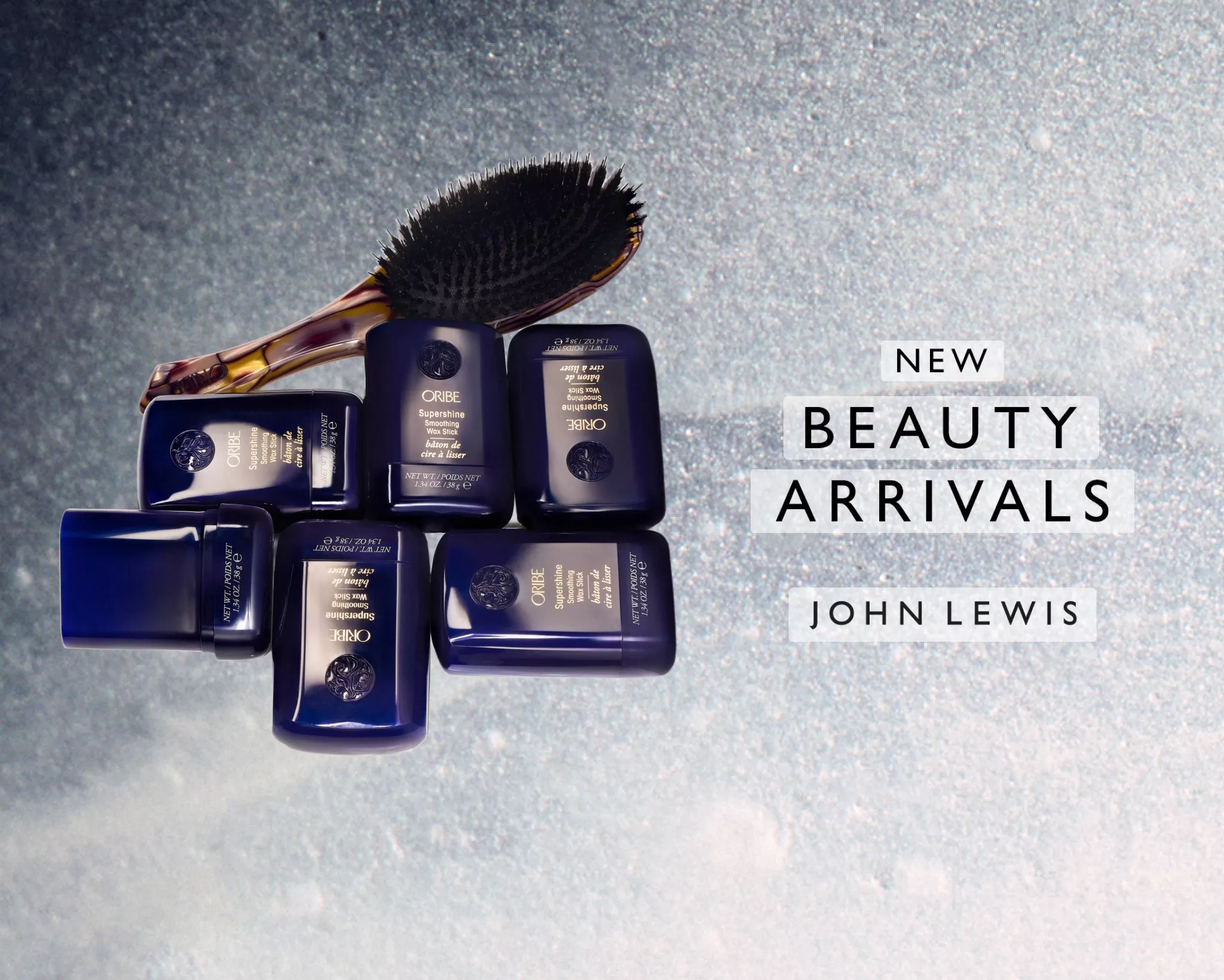 John Lewis new beauty arrivals featuring Oribe Supershine hair wax sticks and a hairbrush on grey background