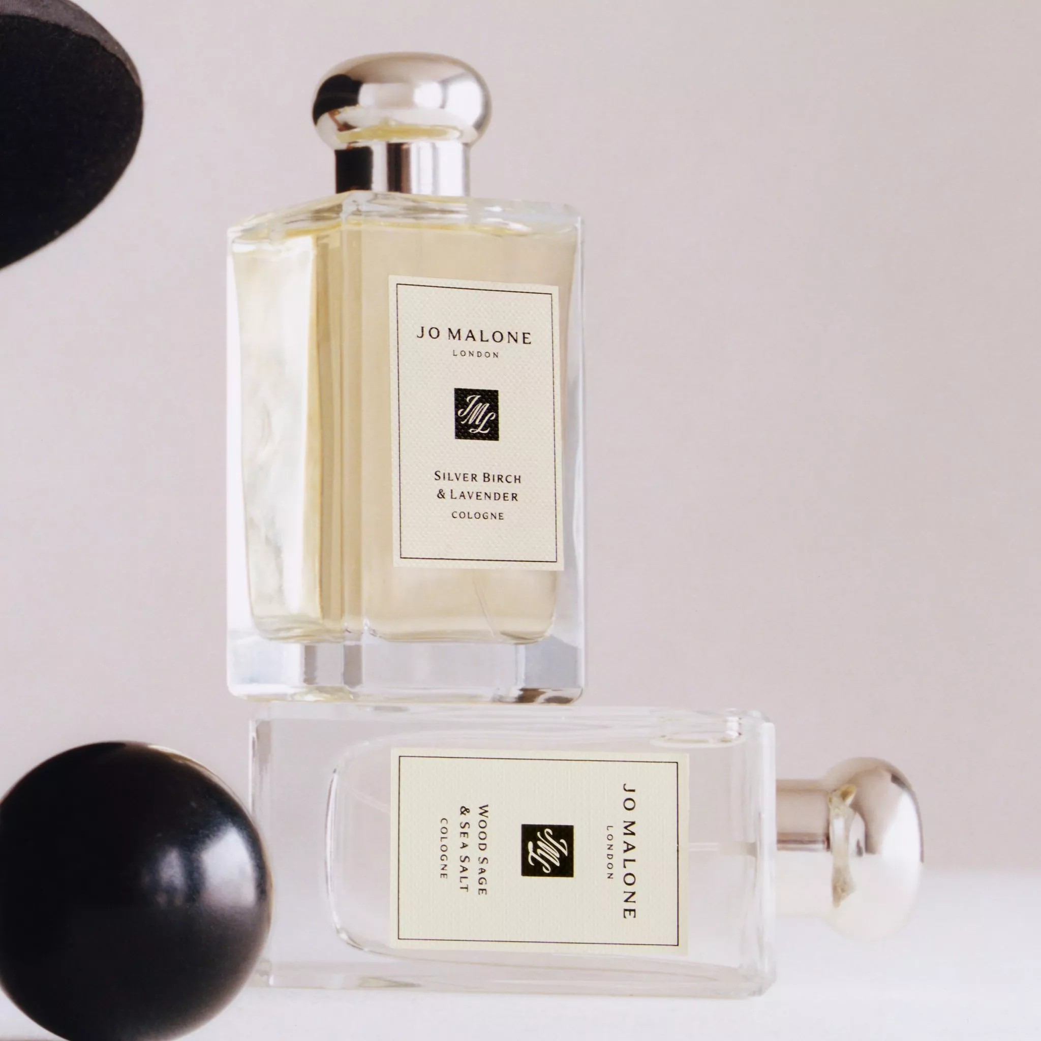 Bottle of Jo Malone London cologne standing on an overturned bottle of cologne