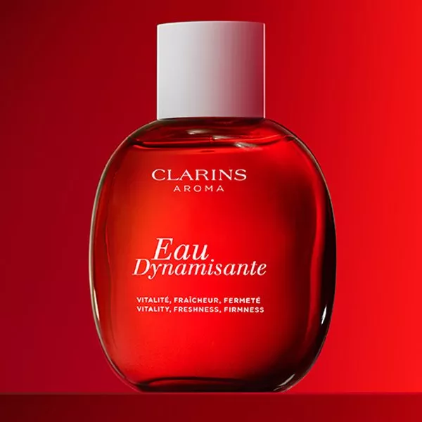 Red bottle of Clarins perfume on a red background