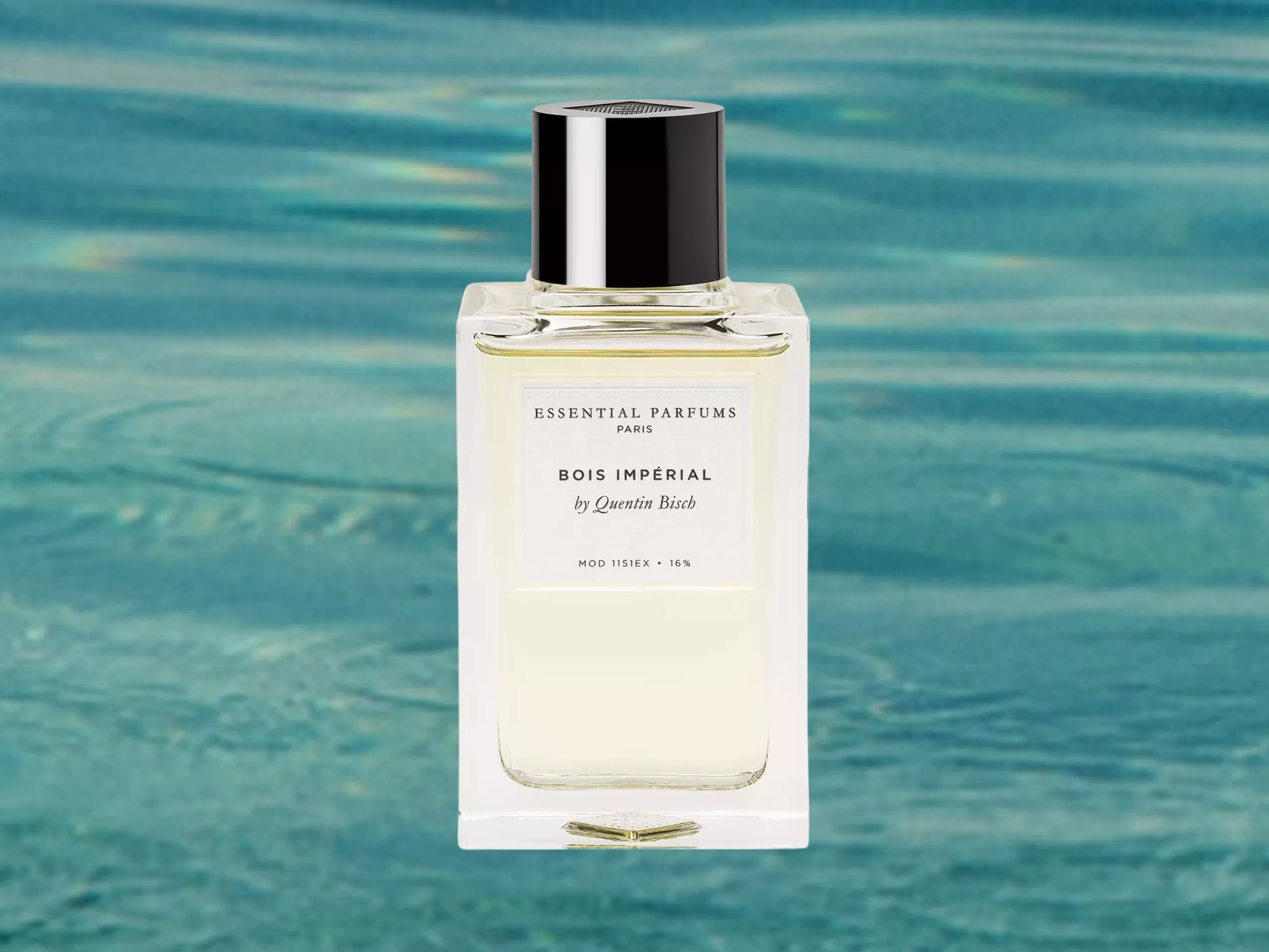 Essential Parfums Bois Impérial perfume bottle with black cap, product shot on turquoise water background