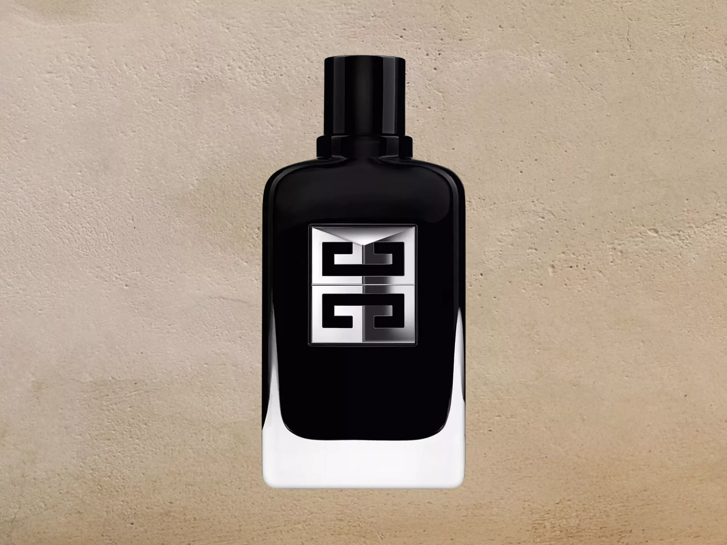 Black Givenchy perfume bottle with silver logo, luxury fragrance product shot on a beige stone background