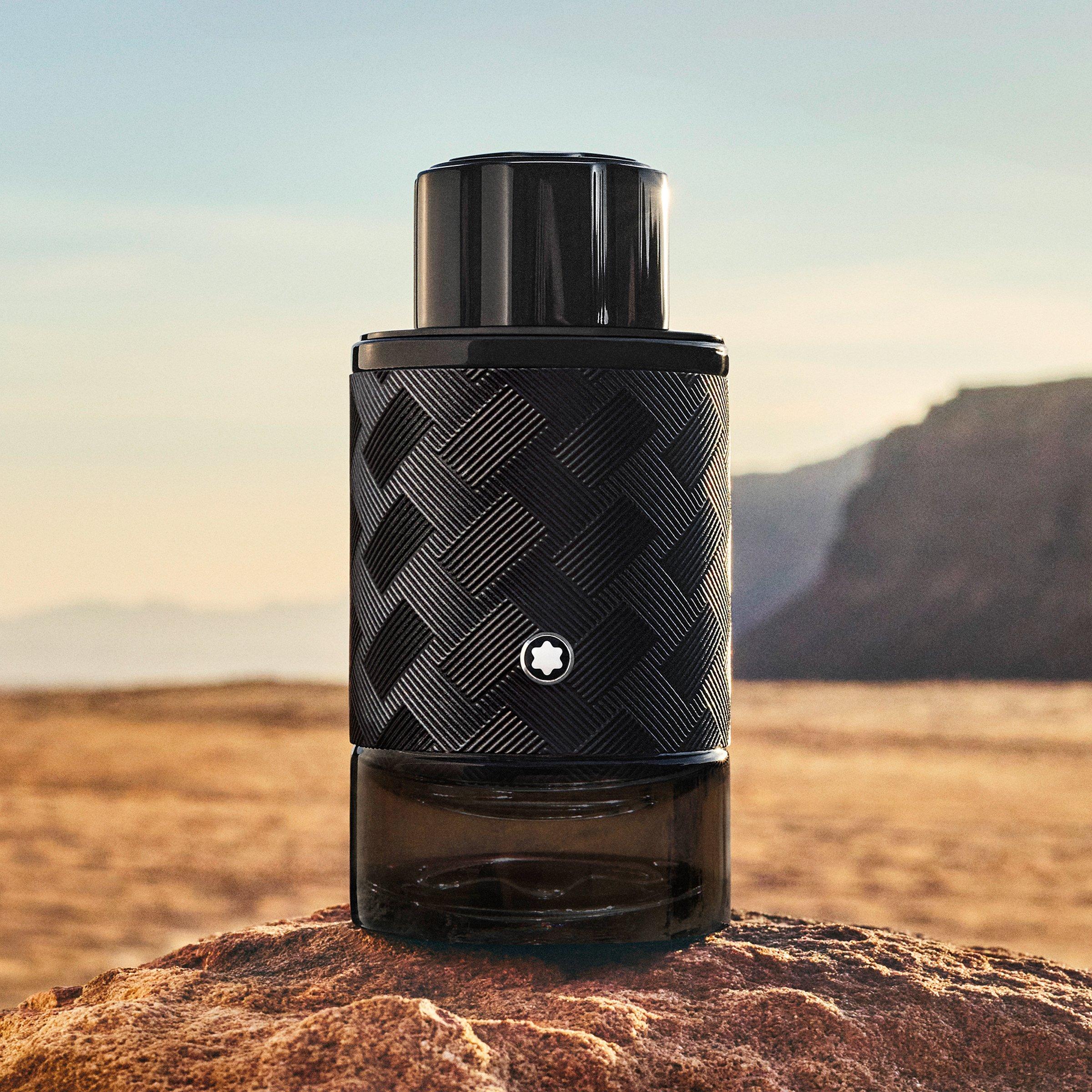 bottle of mont blanc cologne on a beach with cliffs behind it