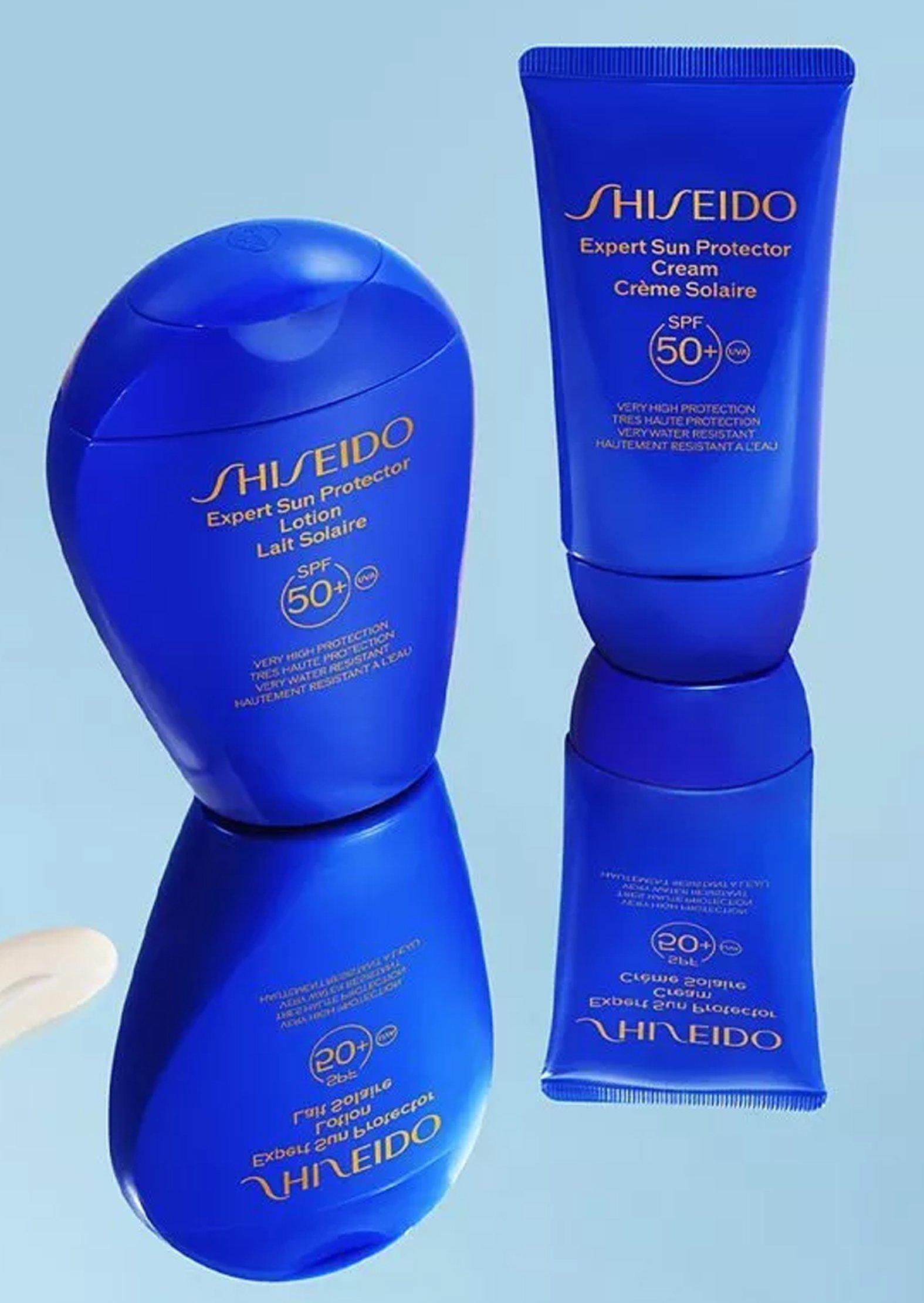 blue bottle of Shiseido sun protector on a blue reflective background