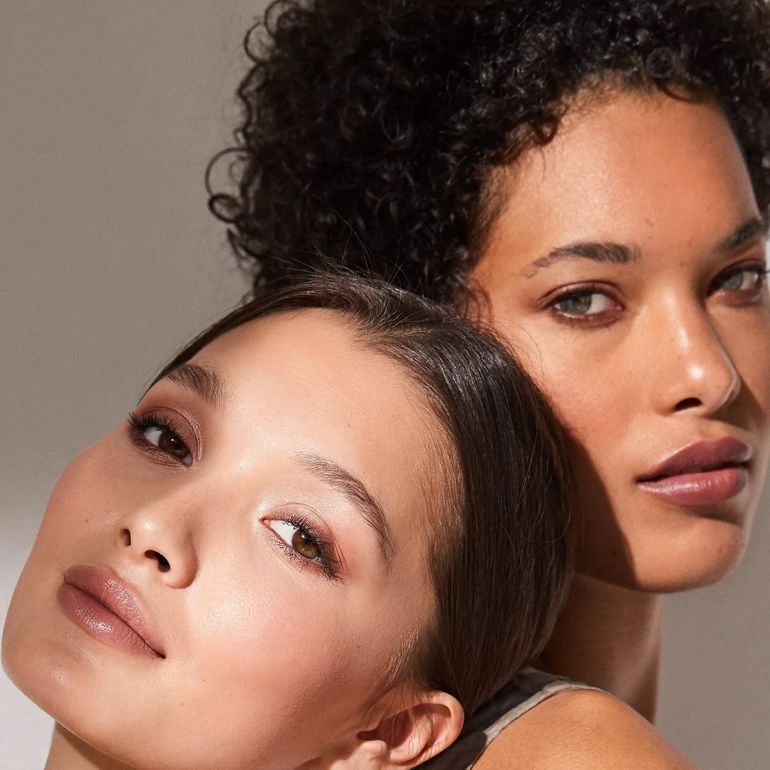 Close-up of two women with natural make-up and glowing skin, showcasing inclusive beauty and skincare results
