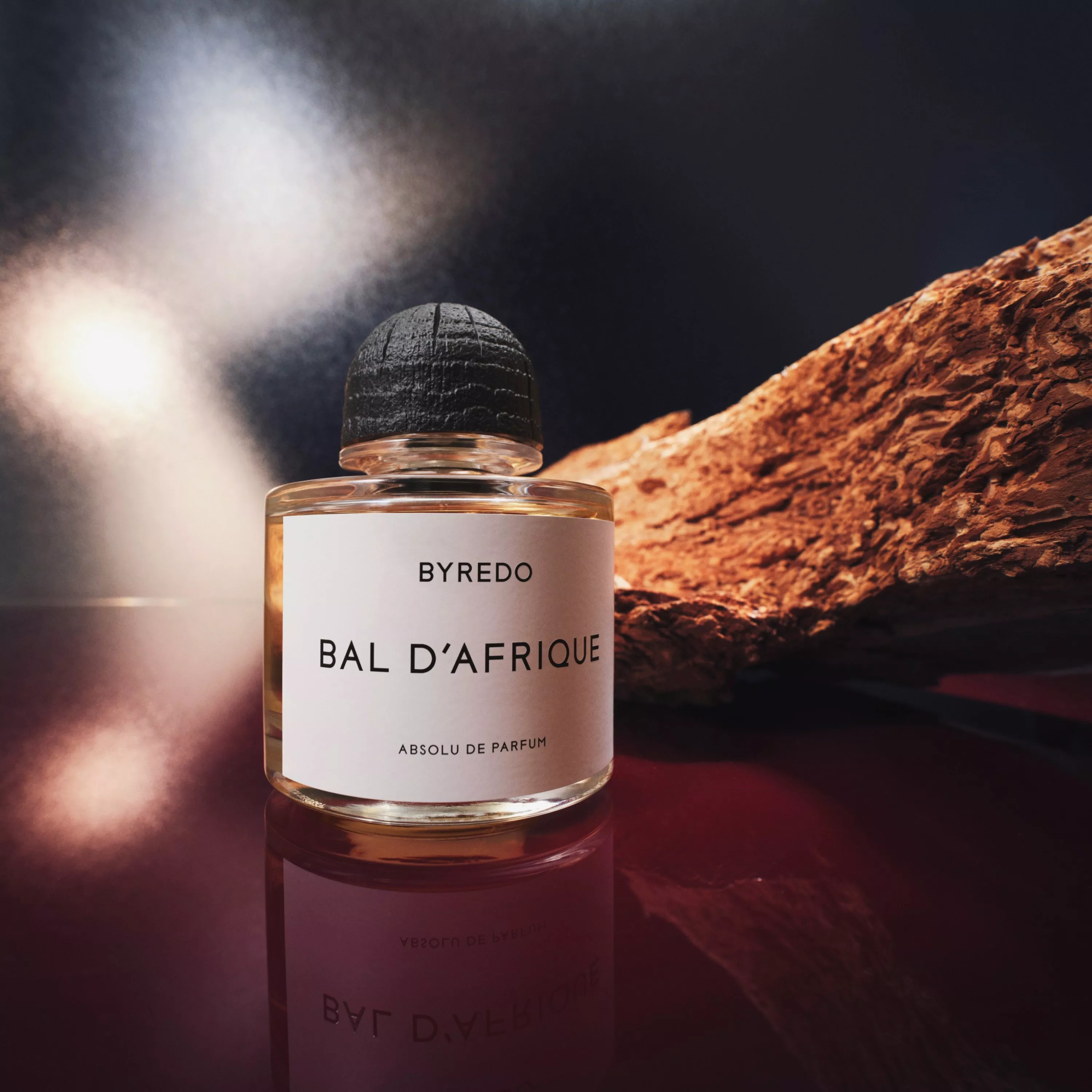 Byredo fragrance sitting next to a branch
