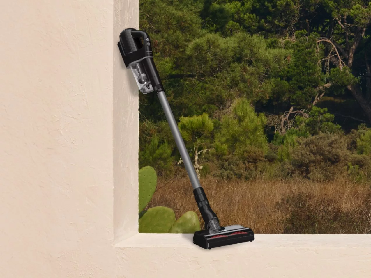 Cordless vacuum cleaner leaning against a wall ledge