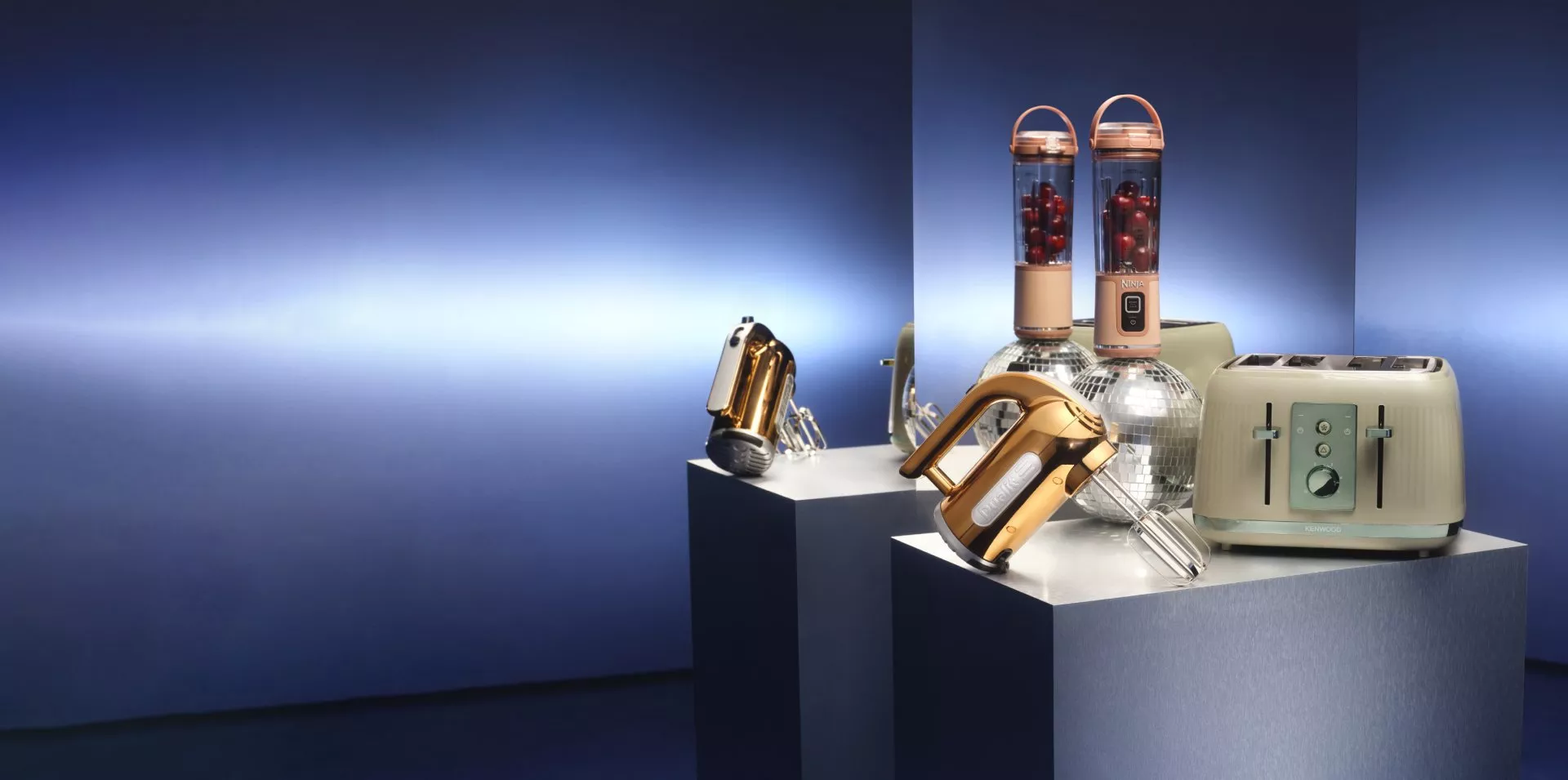 Toaster, blender, electric whisk on a plinth on-top of disco balls with a blue background