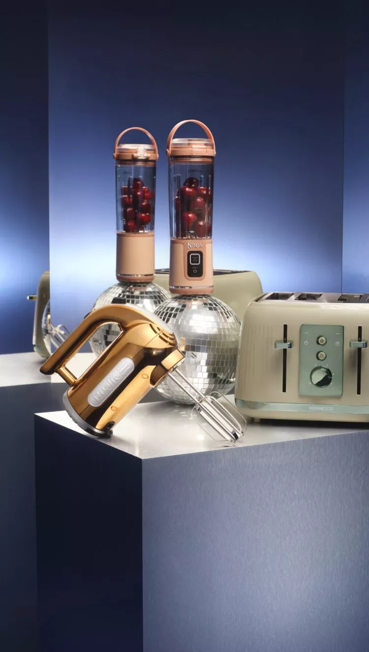 Toaster, blender, electric whisk on a plinth on-top of disco balls with a blue background