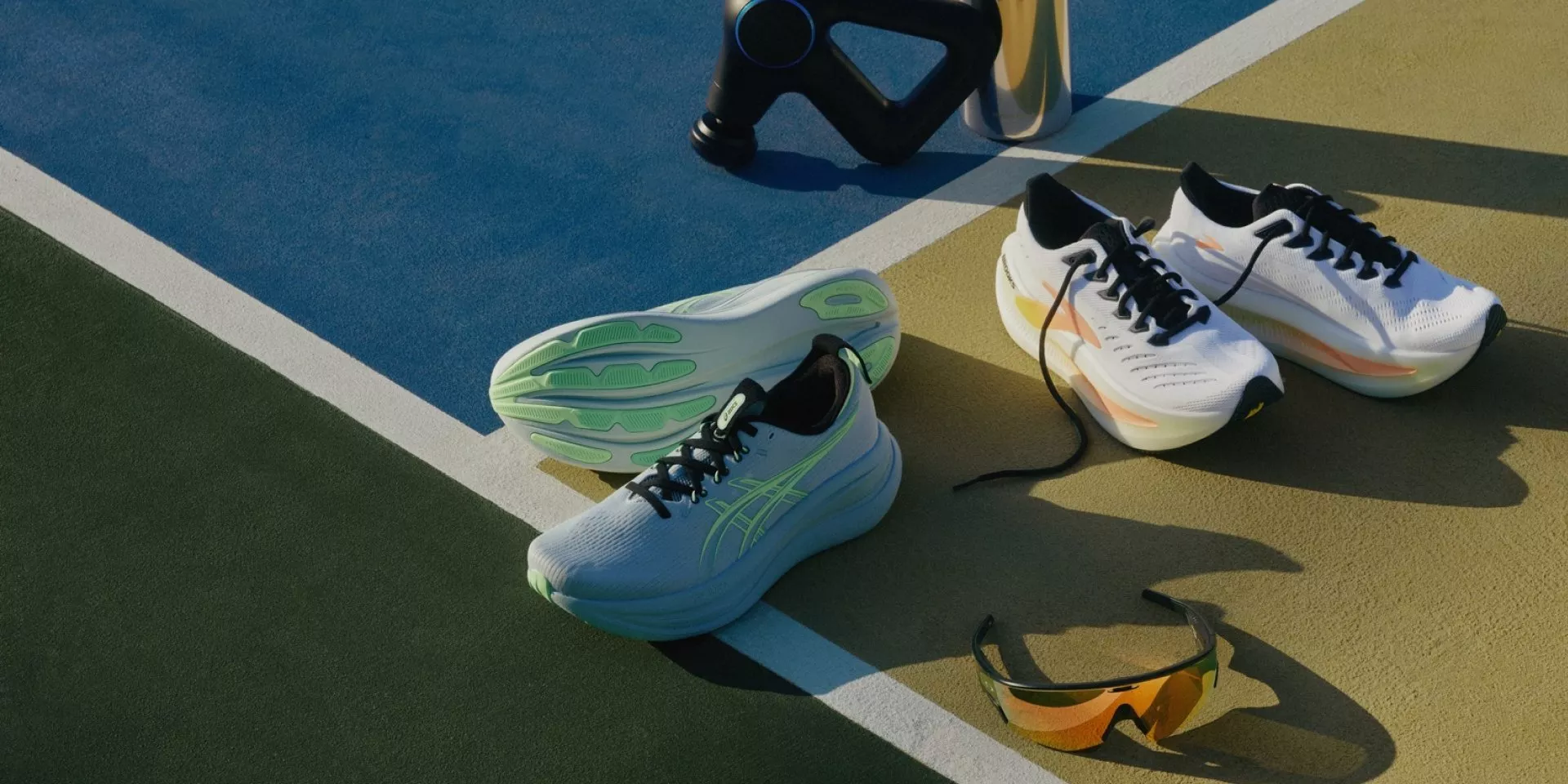 Running shoes and sports sunglasses on an outdoor track court with water bottles, fitness gear in sunlight