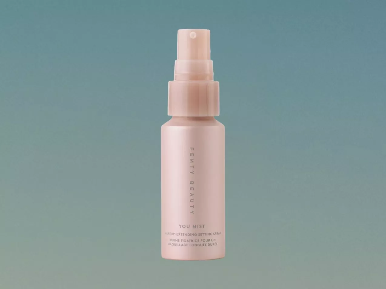 Fenty Beauty You Mist make-up setting spray bottle on teal background, close-up product photography for skincare routine