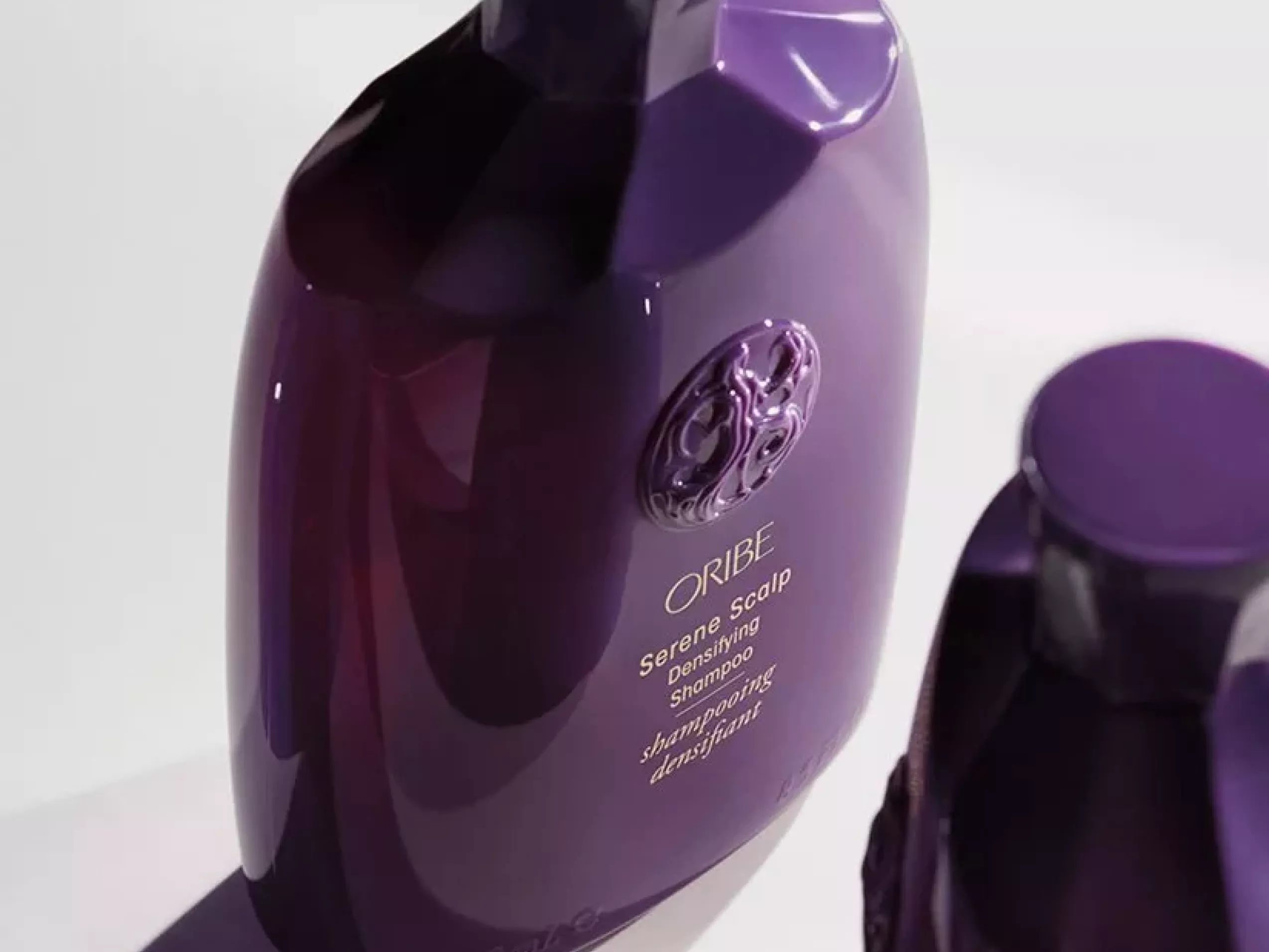 Oribe Serene Scalp densifying shampoo bottle in purple packaging, close-up product shot on white background