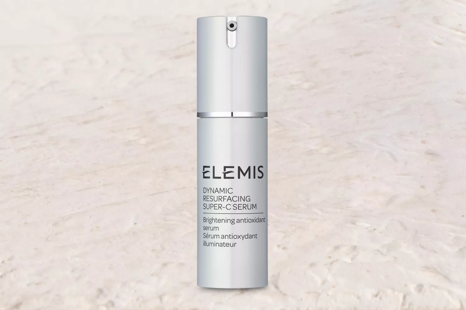Elemis Dynamic Resurfacing Super-C Serum bottle on a coastal background, enhancing skincare appeal.