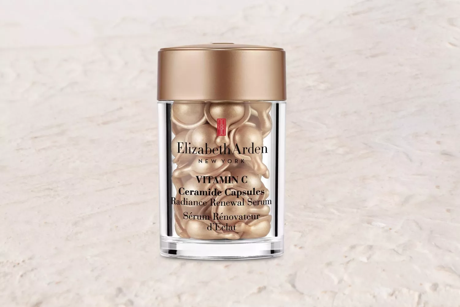 Elizabeth Arden Vitamin C Ceramide Capsules on a stone surface with a scenic coastal background.