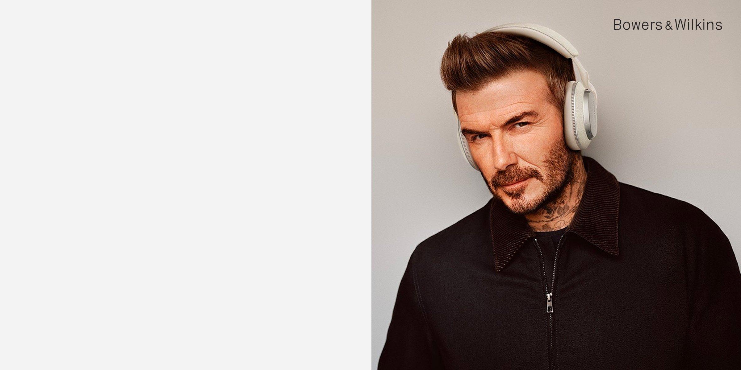 David Beckham wearing white Bowers & Wilkins headphones.