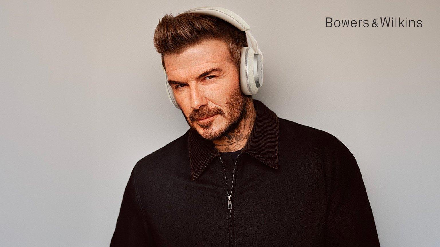 David Beckham wearing white Bowers & Wilkins headphones.