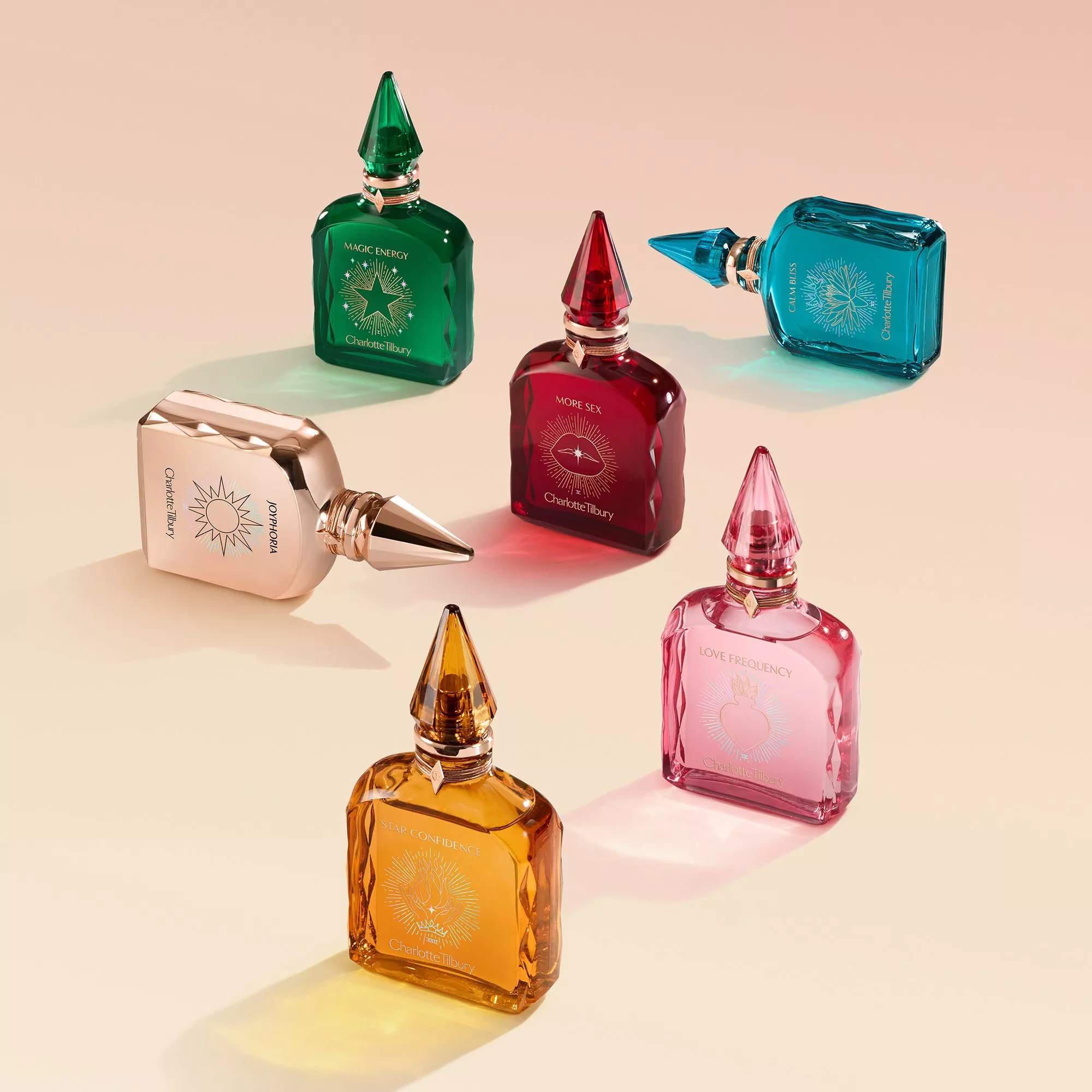 Elegant perfume bottles in vibrant colours arranged creatively on a soft gradient background.