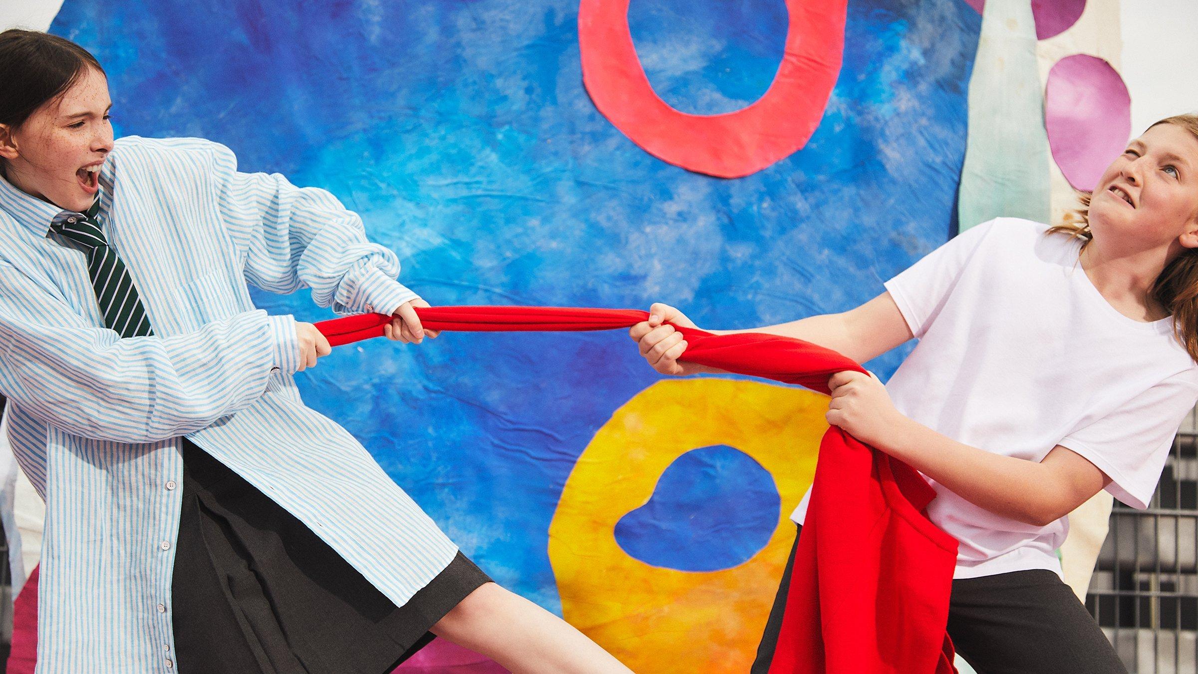 Image of two kids pulling a jumper on the sports playground