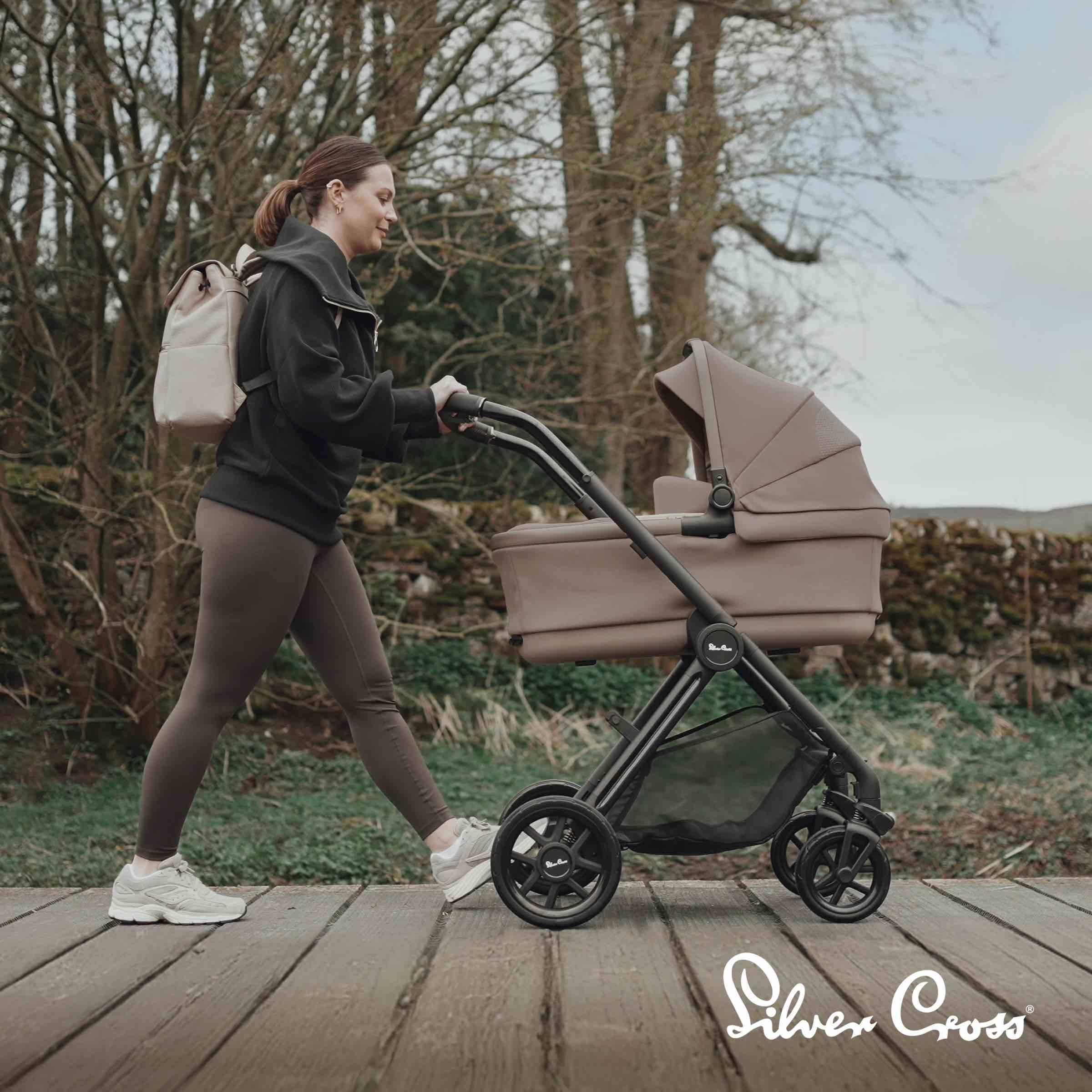 Woman walking with Silver Cross buggy