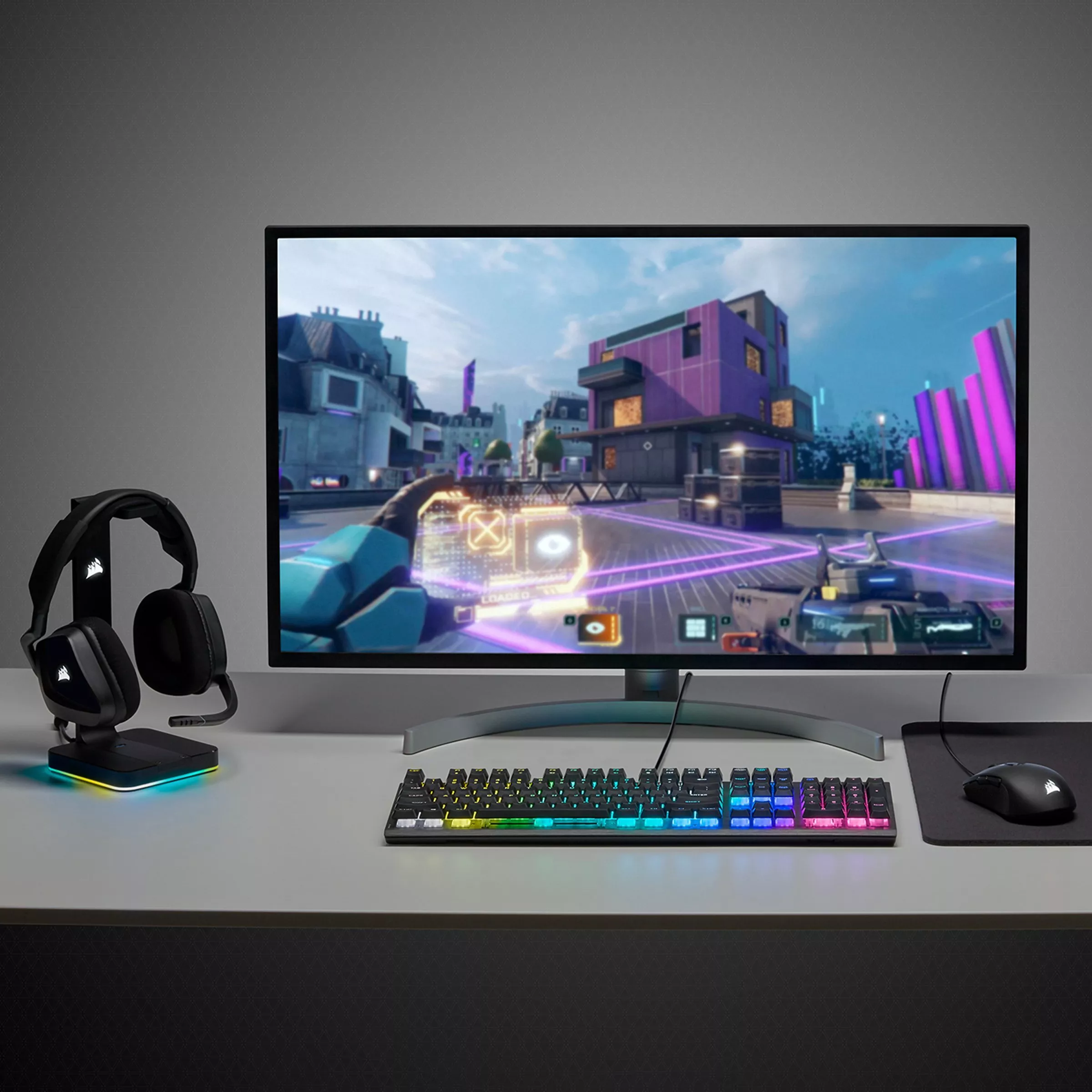 Gaming setup with headphones, RGB keyboard, mouse, and monitor displaying a vibrant action scene. Sleek desk design.