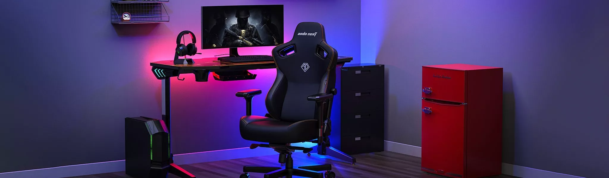 A modern gaming setup with a chair, desk, monitor, and PC. Vibrant LED lights enhance the room's ambience.