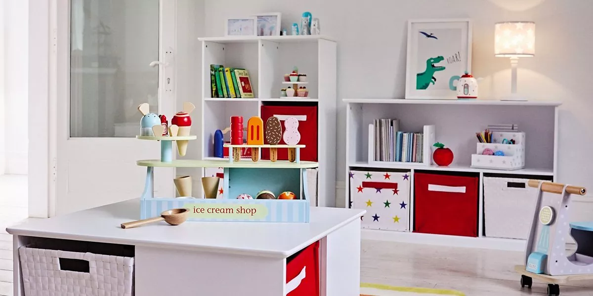 Bright children’s playroom with toy ice cream shop, white storage shelves, colourful bins, lamp and wall art