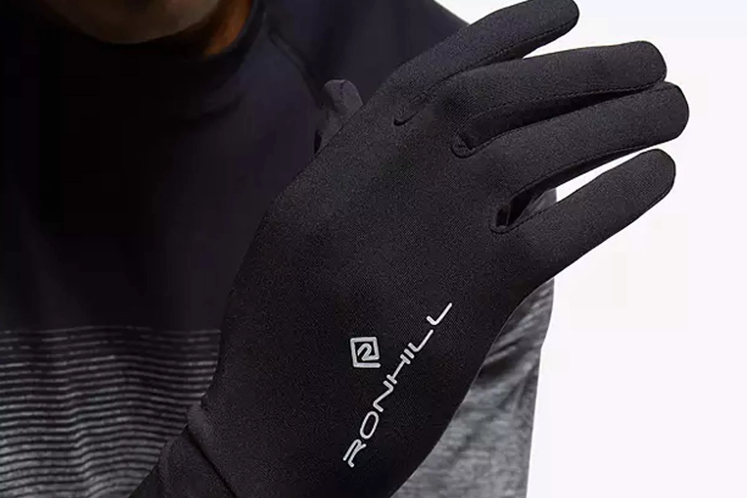 Close-up of black Ronhill running glove on hand, lightweight thermal fabric for winter sports training outdoors