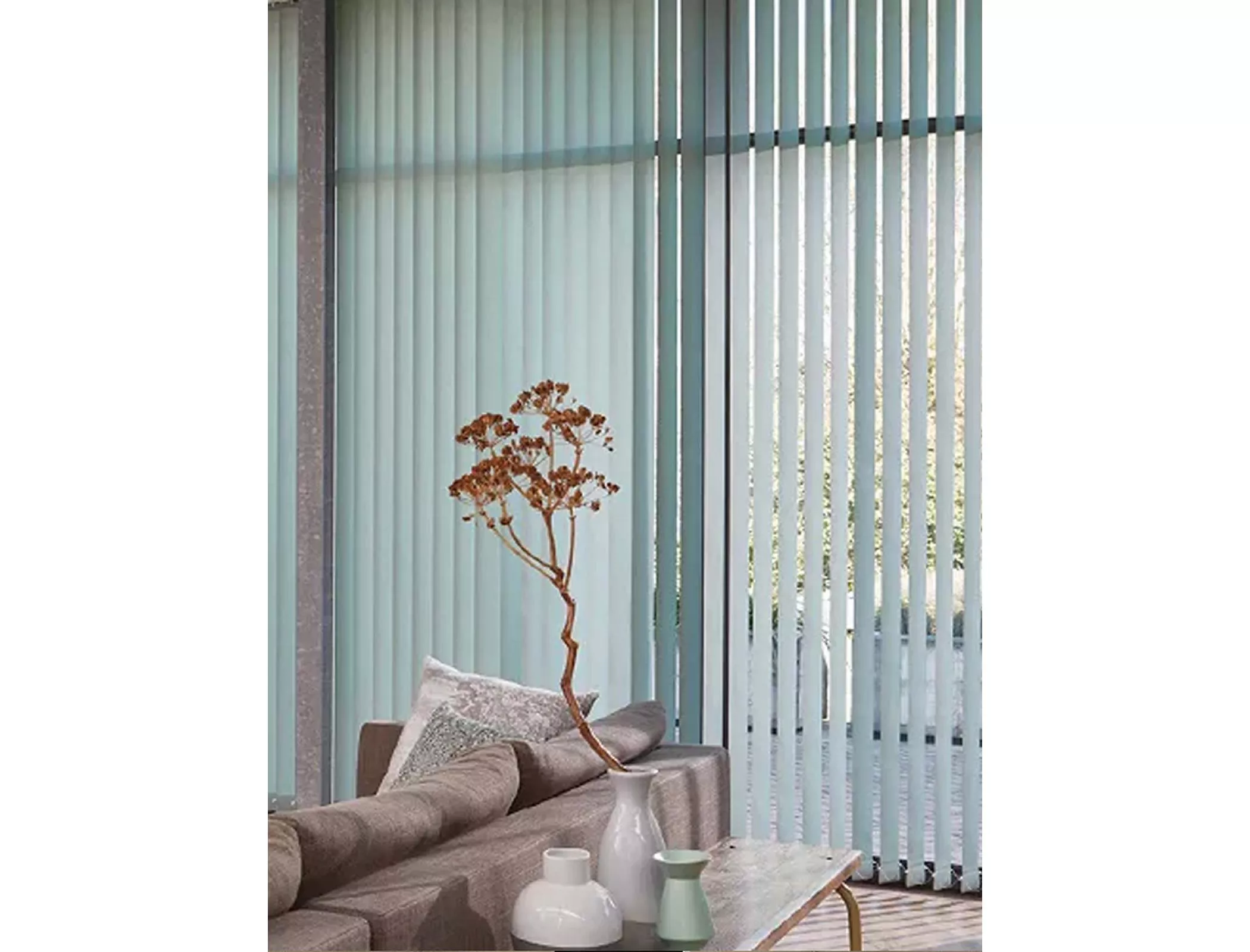 Light blue vertical blinds on large window, modern living room with sofa, cushions and vase decor in daylight