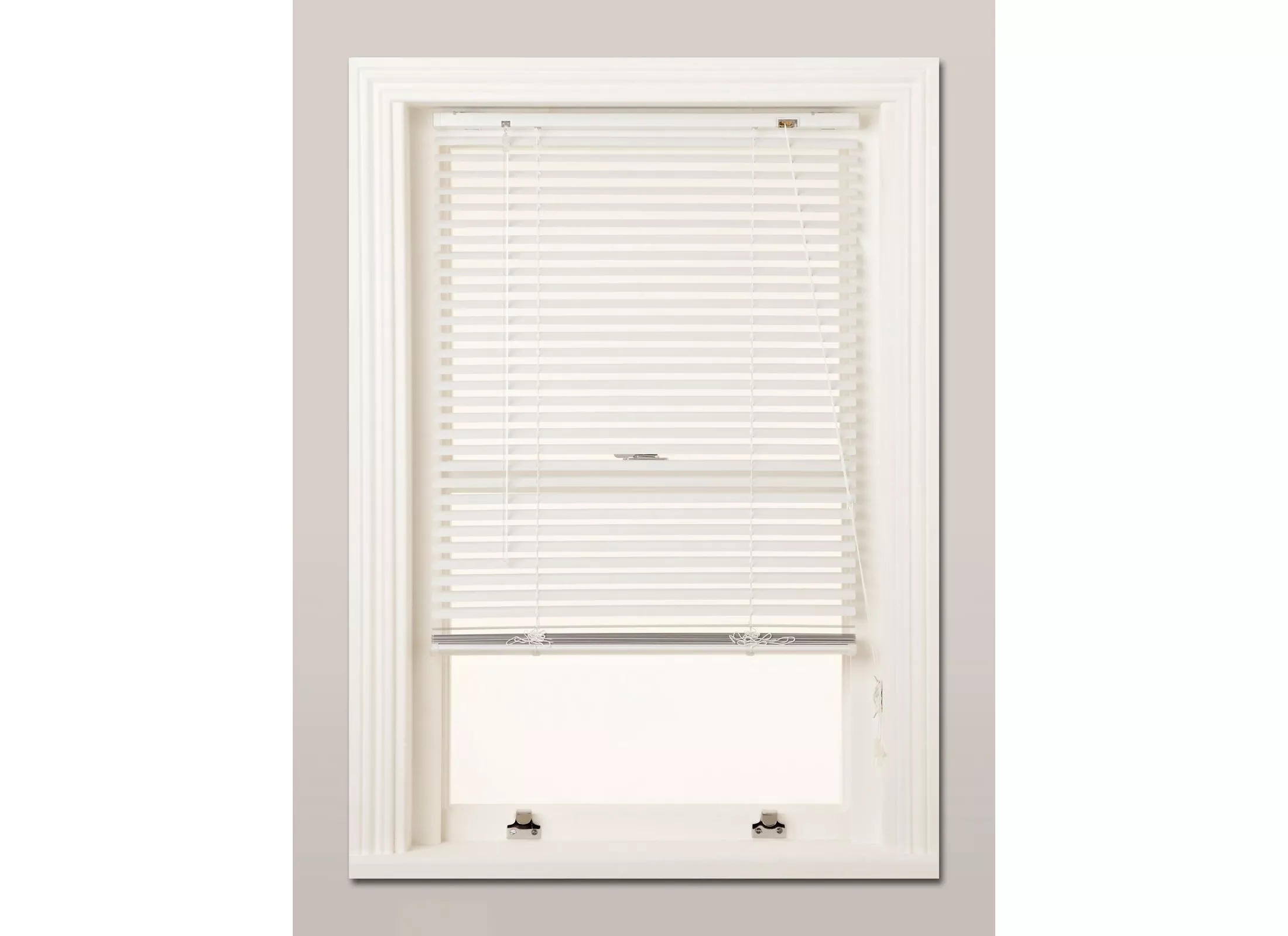 White venetian blind fitted to sash window, adjustable slats for privacy and light control in modern home.