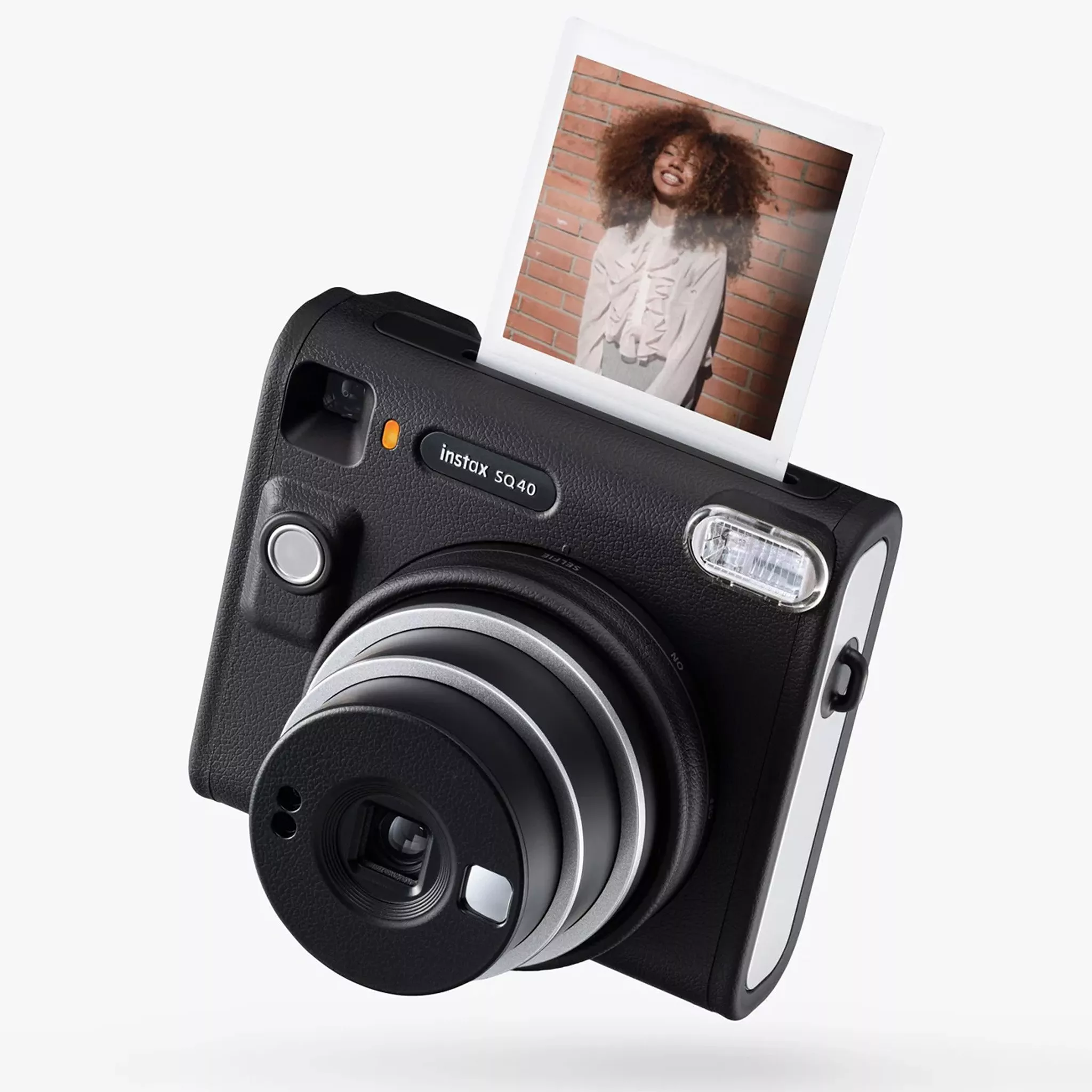 instant camera with photo being printed out from camera