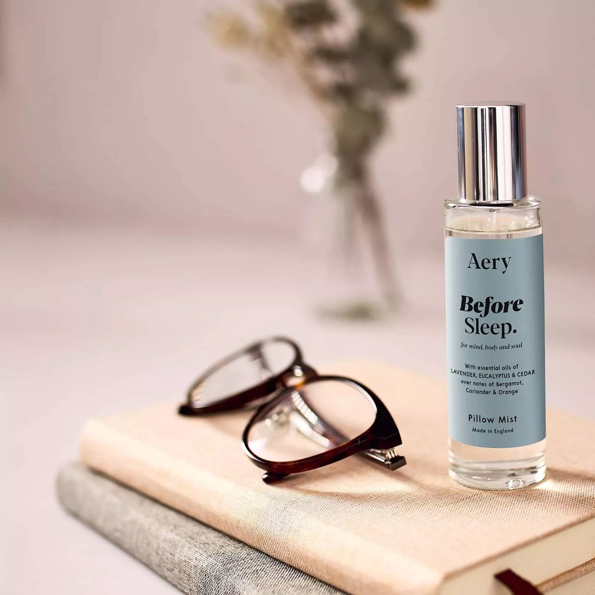 Room spray on a book beside reading glasses