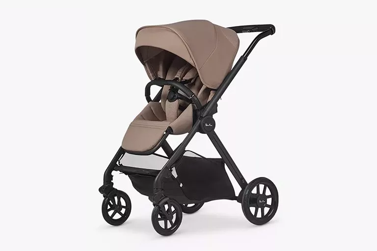 A beige baby stroller with a sleek black frame, featuring a canopy and storage basket, on a white background.