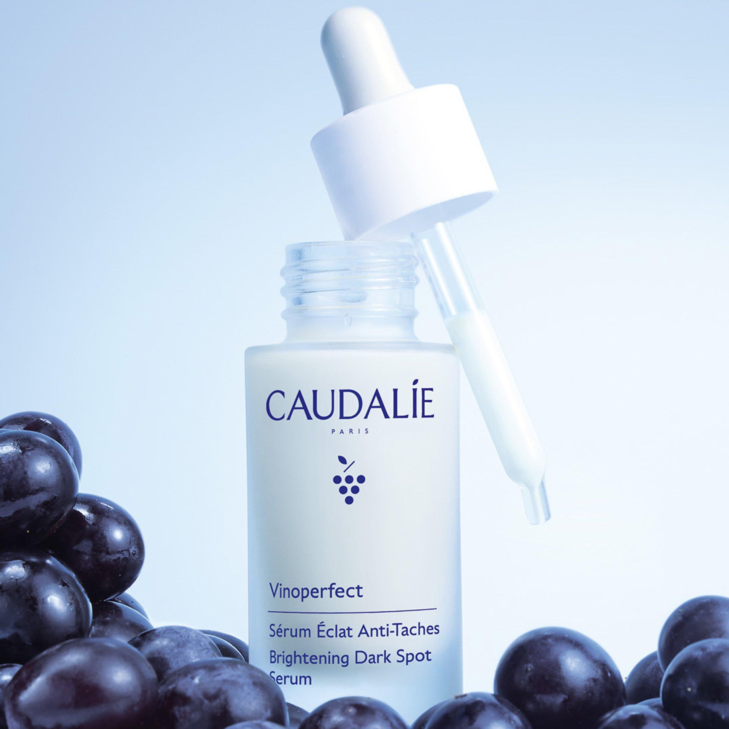 Caudalie Beauty serum open bottle with dropper and grapes at the side