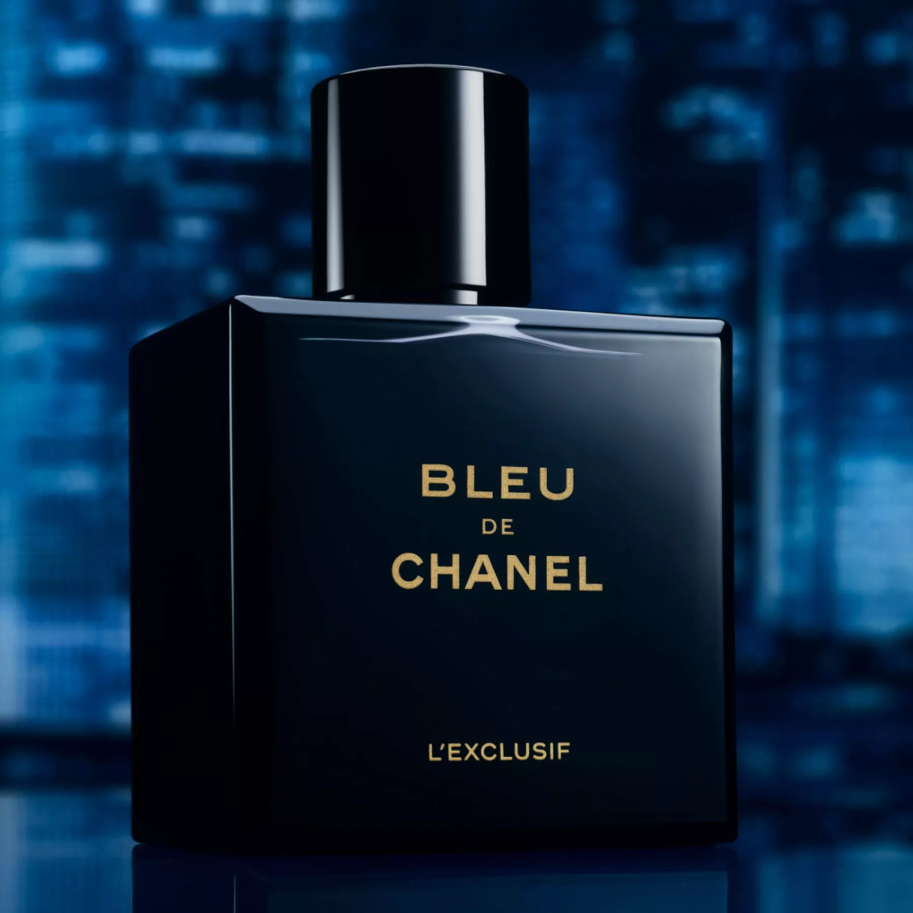 Bleu de Chanel L’Exclusif fragrance bottle in sleek black glass, studio product shot on blue backdrop