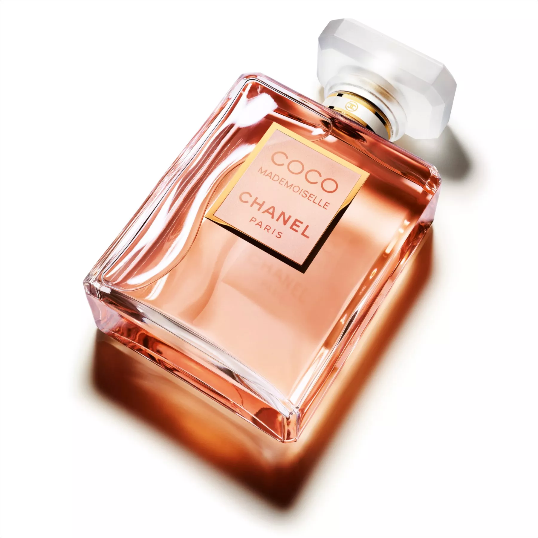 Chanel Coco Mademoiselle perfume bottle with pink fragrance in glass, close-up product shot on white background