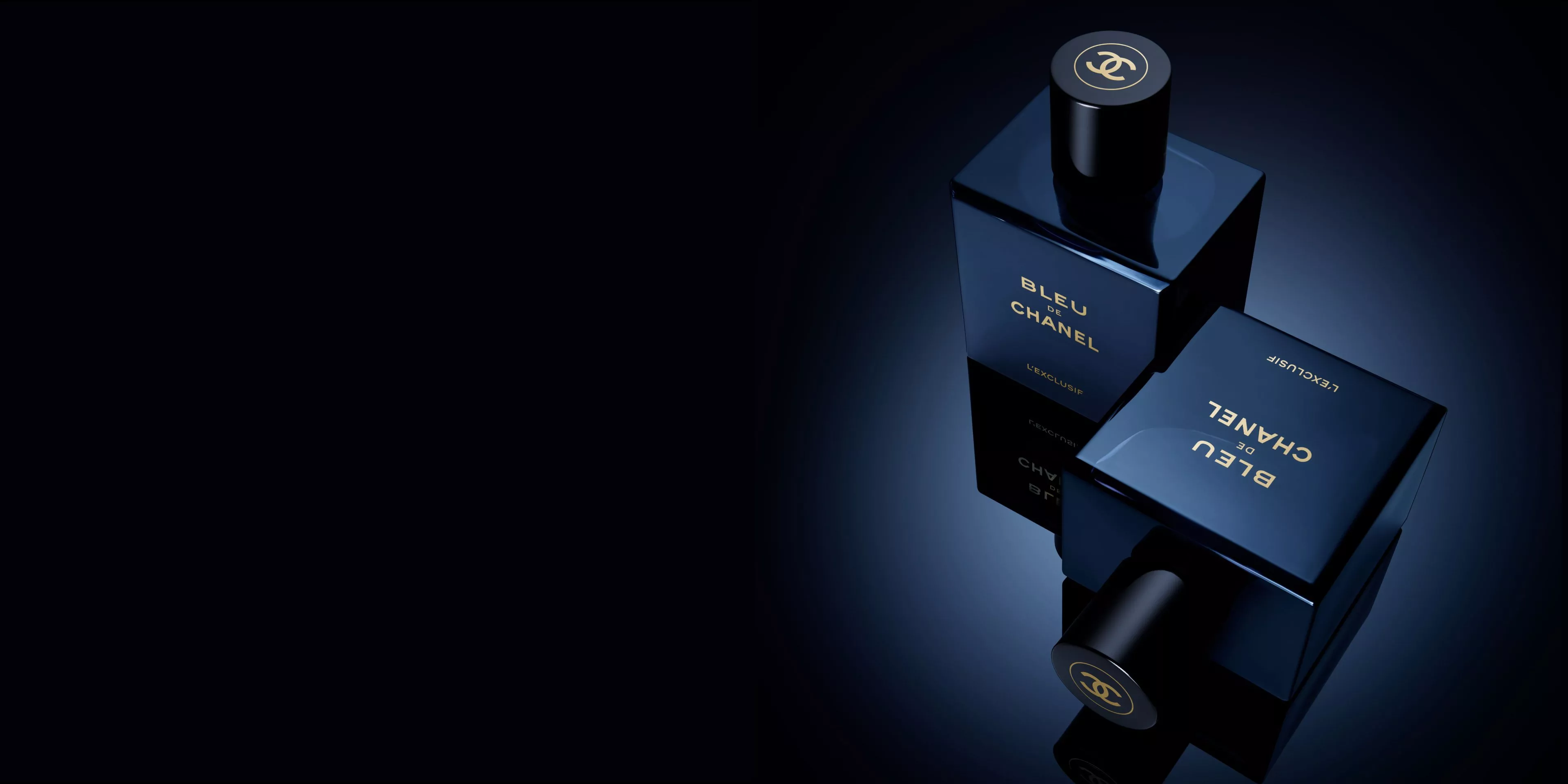 two square, dark navy blue glass bottles of Bleu de Chanel L'Exclusif fragrance