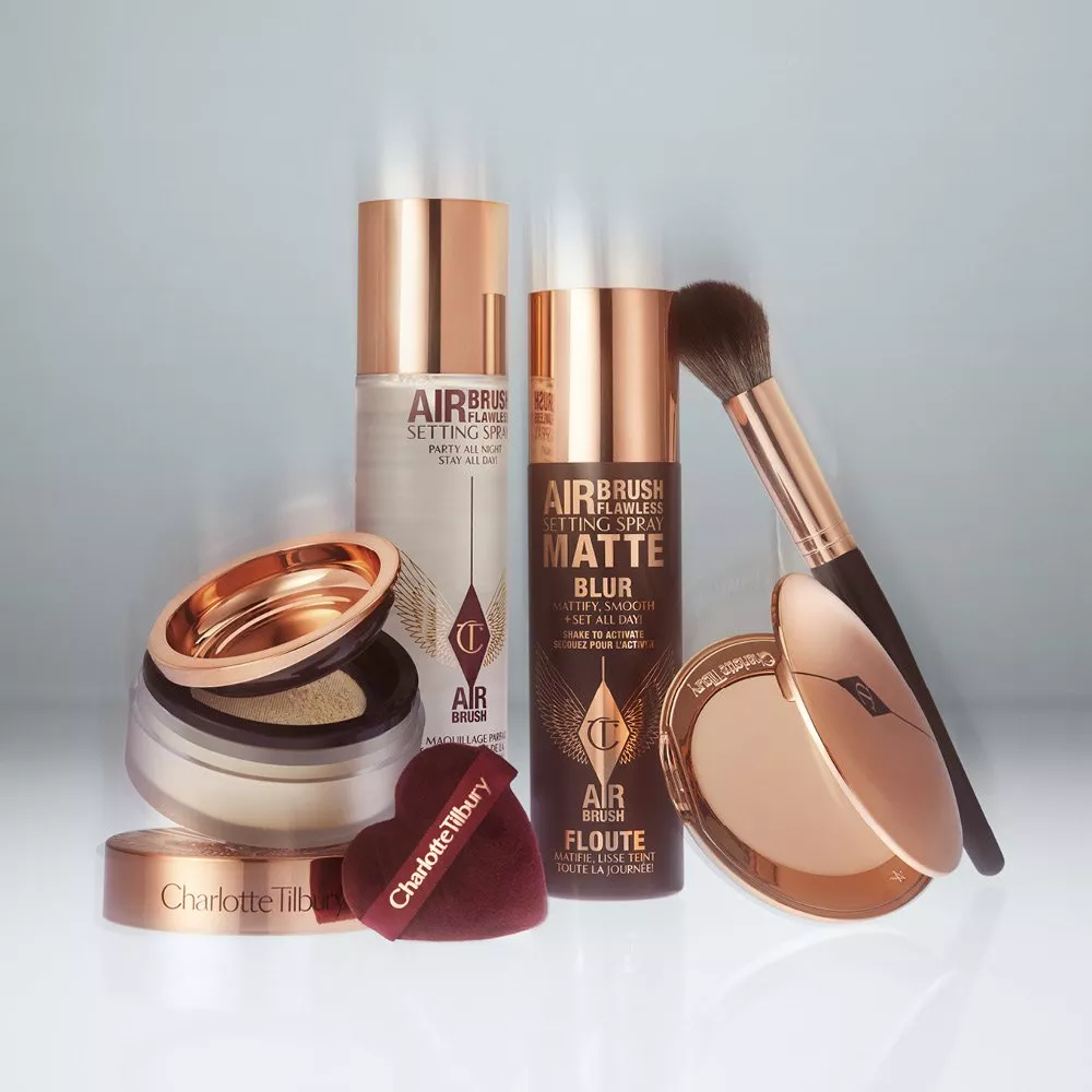 Charlotte Tilbury Airbrush Flawless setting spray, compact powder and brush in rose gold packaging on grey background