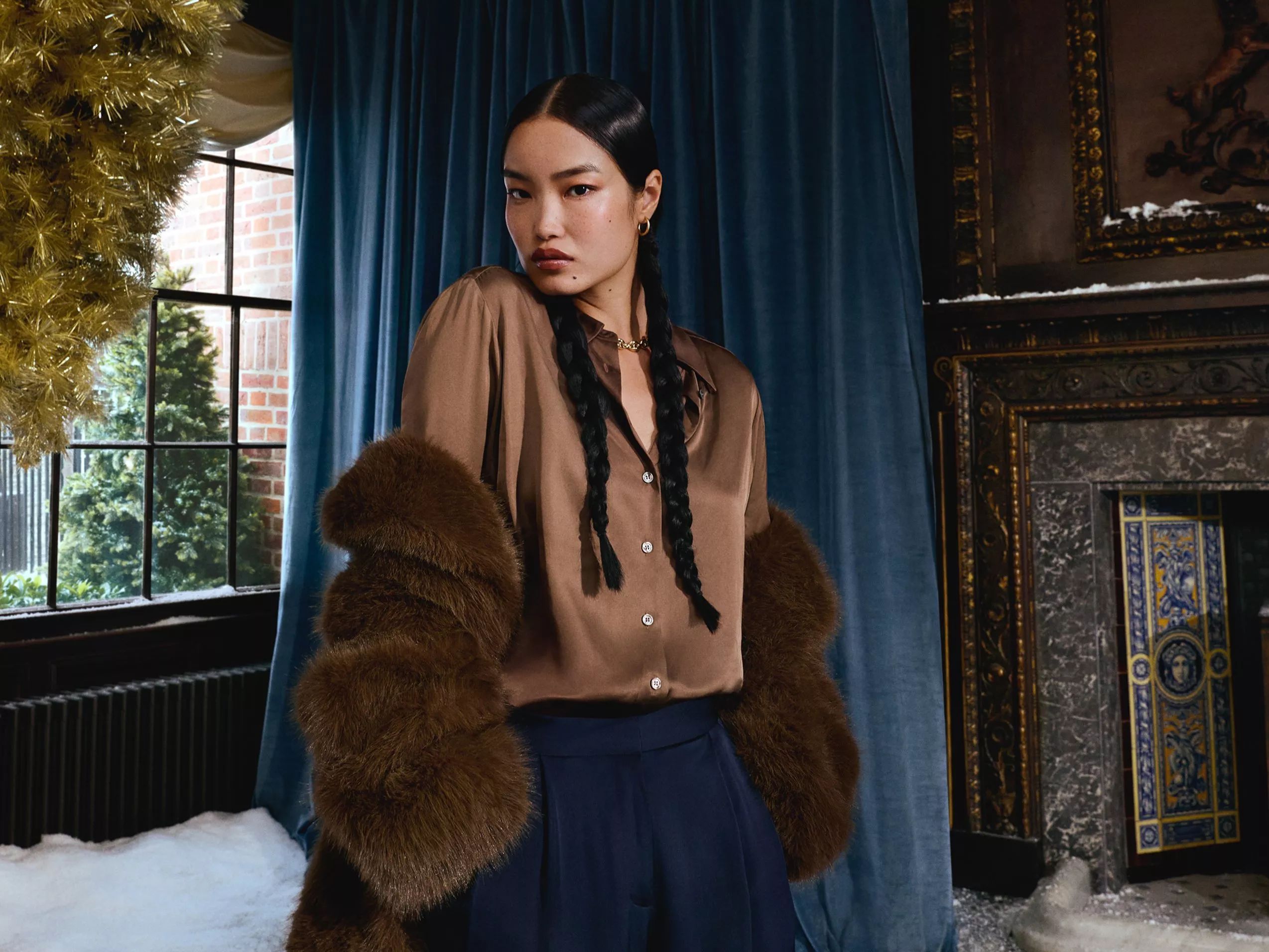 Woman wearing a brown satin shirt and faux fur brown coat