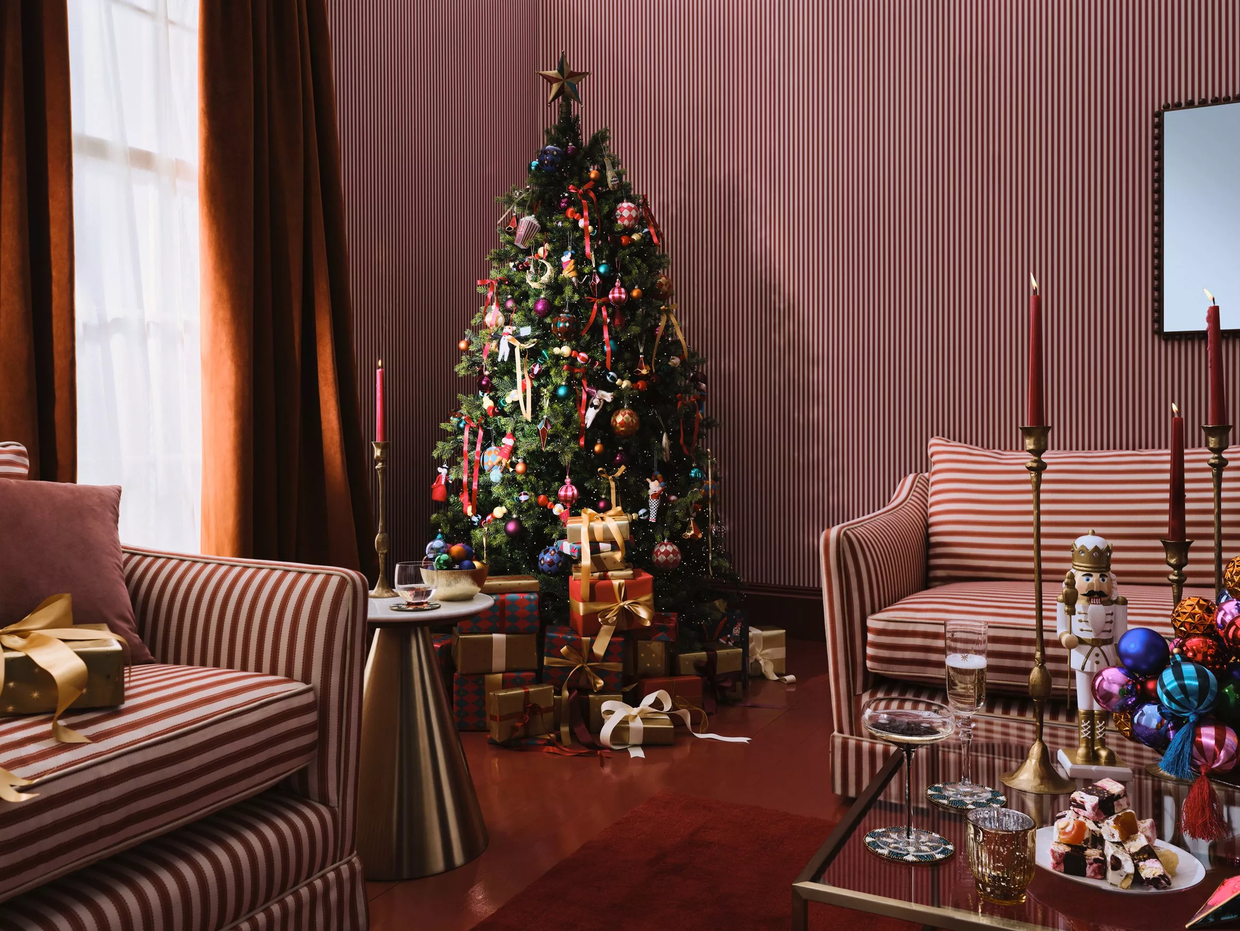 Christmas tree next to two striped sofas 