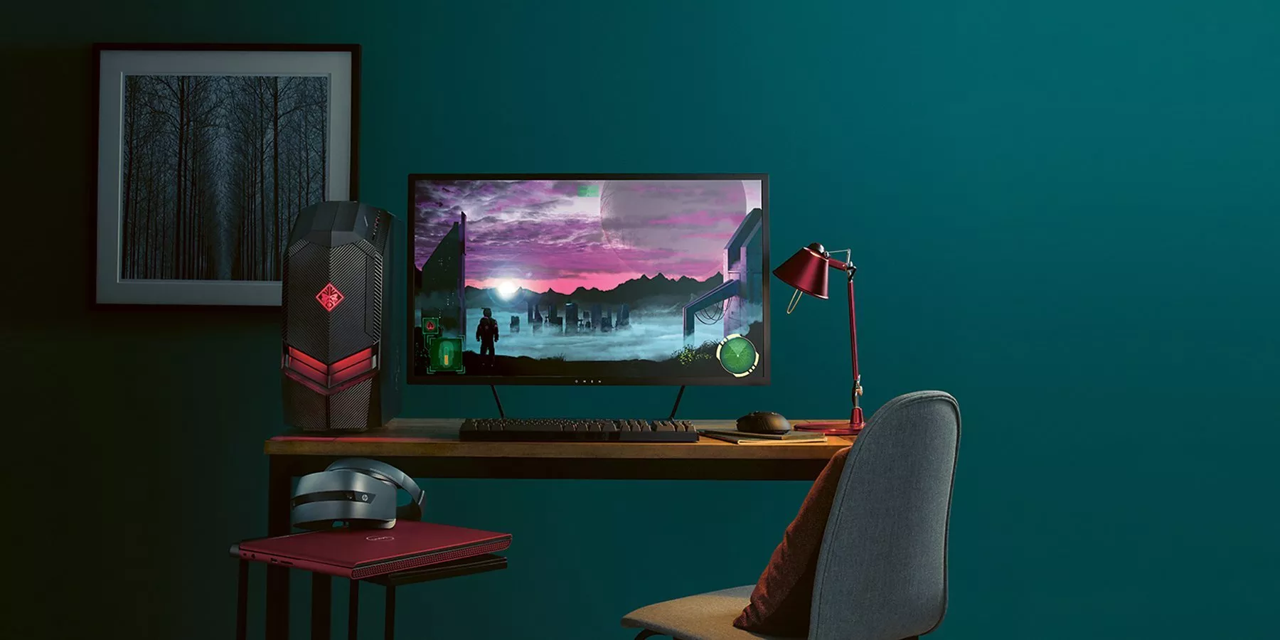 Gaming setup featuring a desktop PC, monitor displaying a futuristic landscape, keyboard, mouse, and lamp.