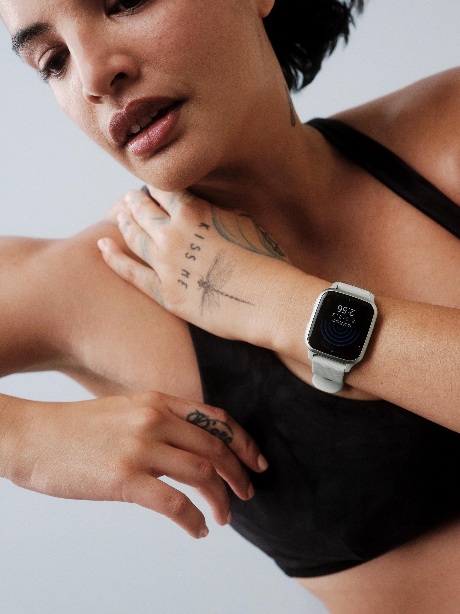 Close-up of athlete wearing fitness smartwatch with heart-rate screen