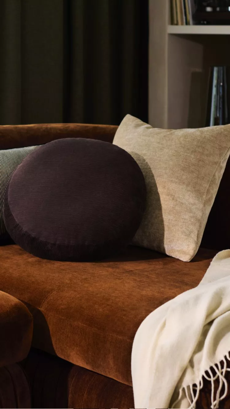 Burnt orange orange with scatter cushions and a blanket