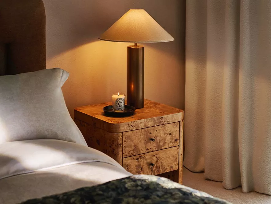 White sheer curtains alongside dark green curtains behind a brown corner sofa