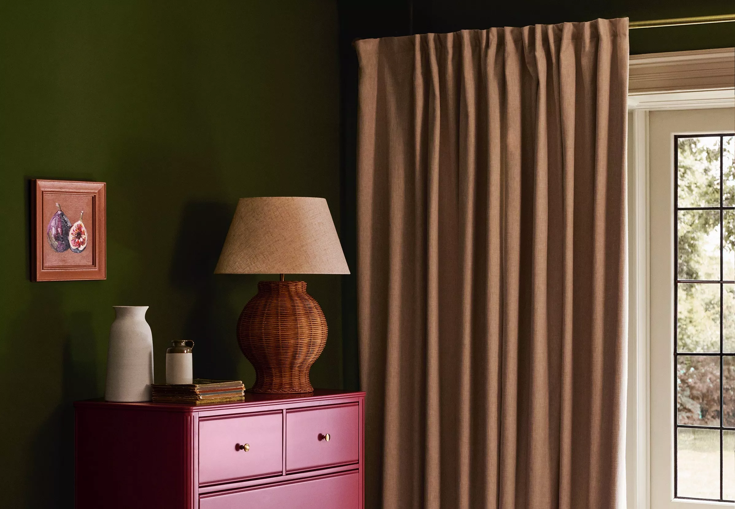 Room with chest of drawers next to floor length curtains on a patio window