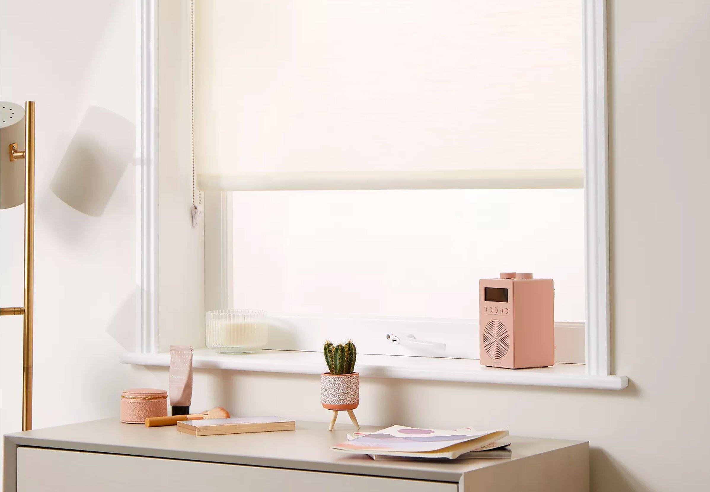 White ready made blinds with a desk and plant in front of the blind