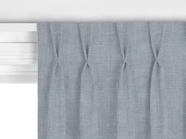 Close-up of grey pleated curtain header with pinch pleats, showing textured fabric and window blind edge