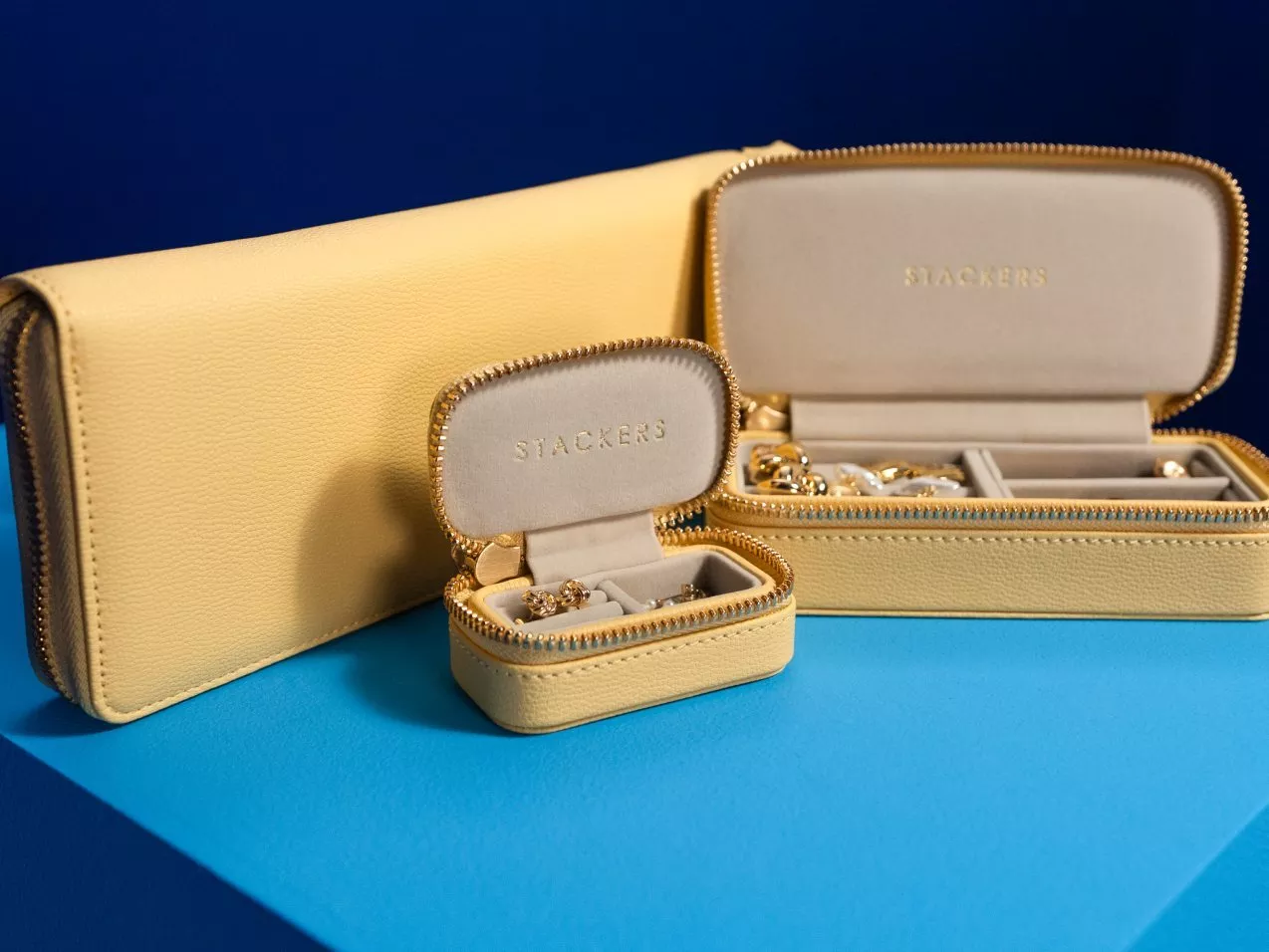 Yellow Stackers travel jewellery boxes with gold zip, open to show organised ring and earring storage compartments