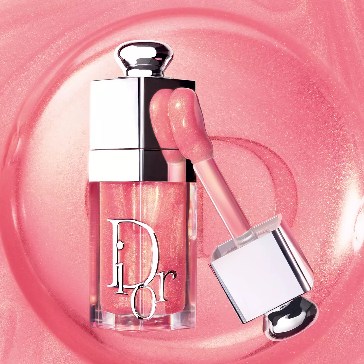 Dior pink lip gloss with applicator wand, sparkling shimmer texture on glossy pastel backdrop, beauty product close-up