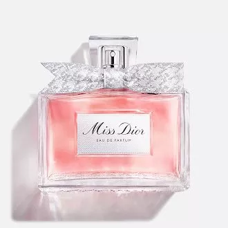 Miss Dior Eau de Parfum bottle with pink fragrance, silver bow and glass flacon on white background