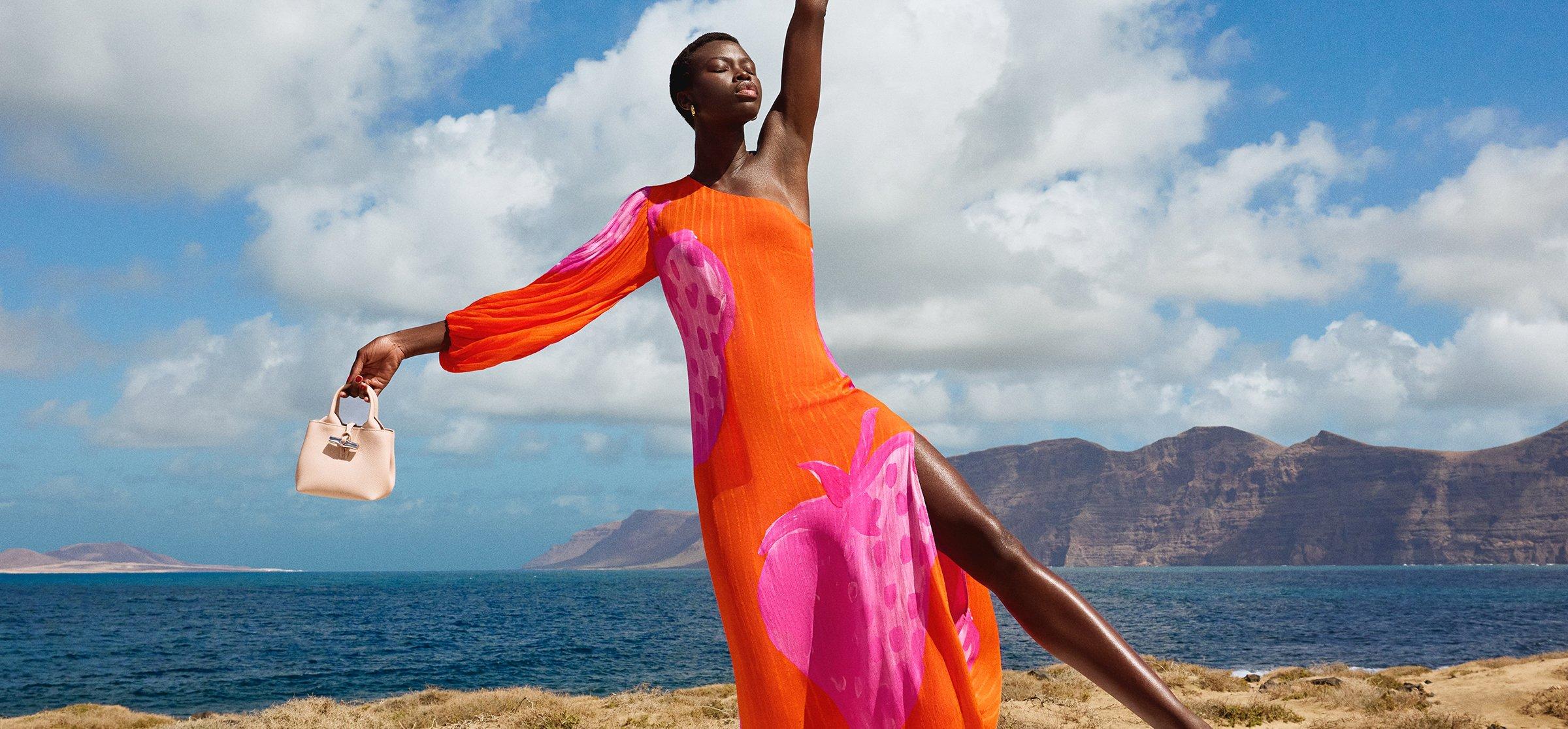 Female model wearing bright red and pink maxi dress